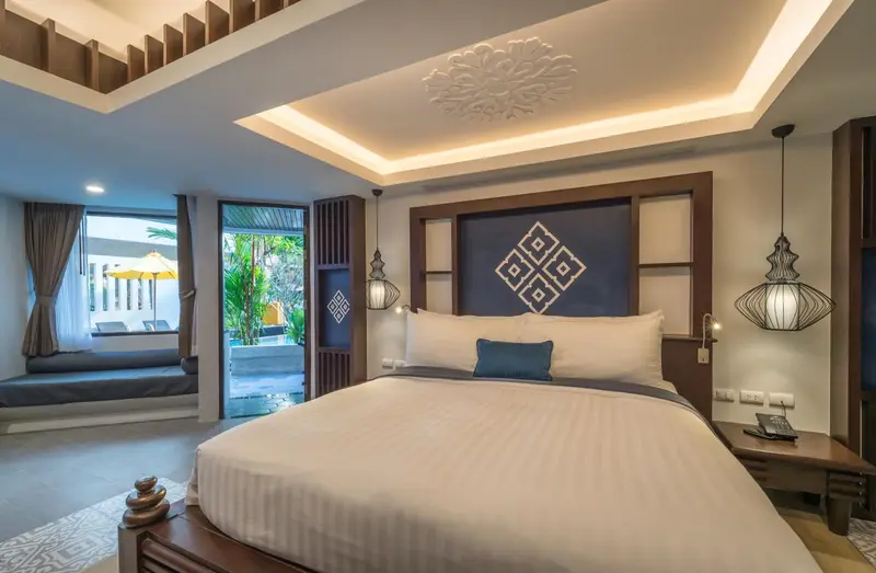 Une chambre lumineuse avec un grand lit et un accès à une terrasse.