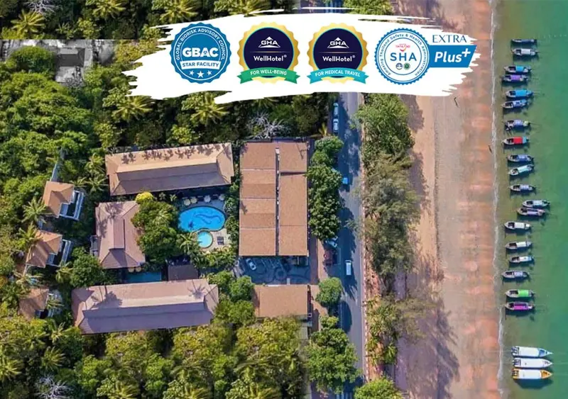 Vue aérienne d'un complexe hôtelier tropical avec piscine et accès à la mer.