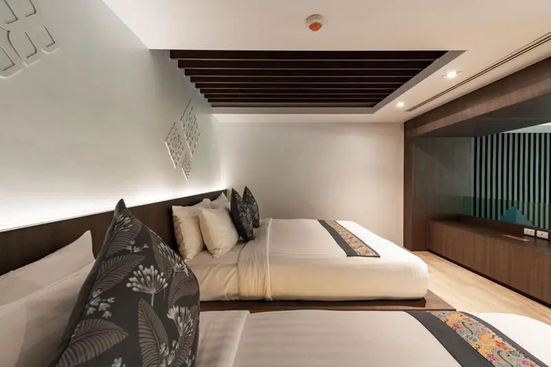 Une chambre moderne avec un grand lit et des oreillers décoratifs.