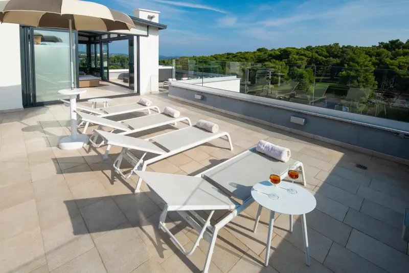 Terrasse aménagée avec transats et tables d'appoint.
