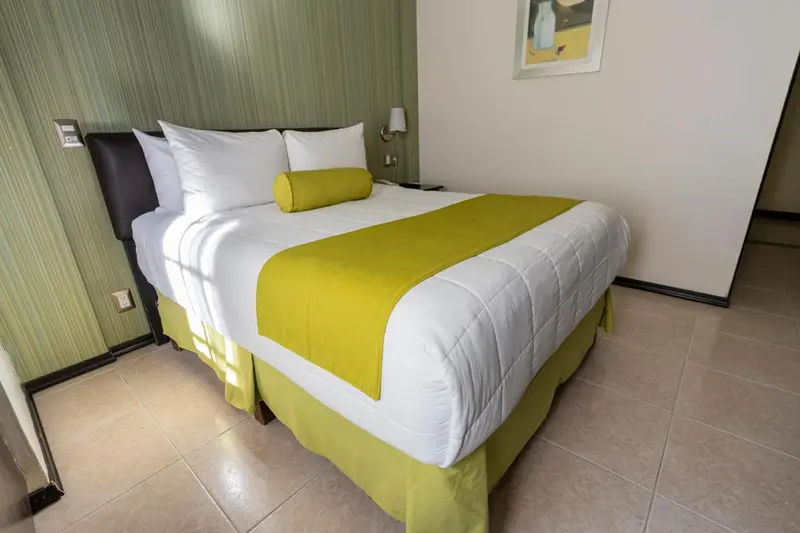 Une chambre lumineuse avec un lit double et une décoration sobre.