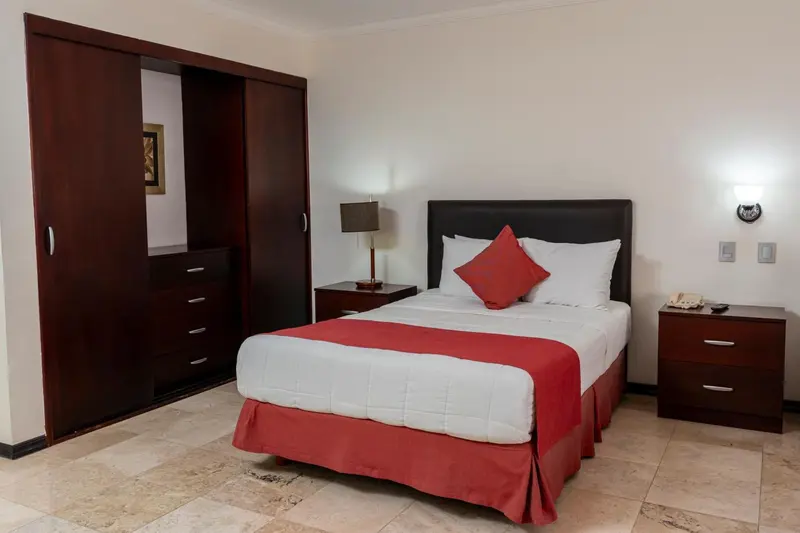 Une chambre avec un lit double et des meubles en bois.
