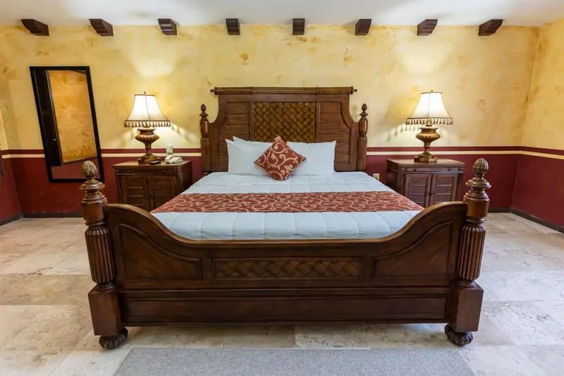Une chambre à coucher avec un grand lit en bois sculpté et des lampes de chevet.