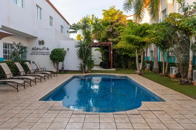 Une piscine rectangulaire bordée d'une terrasse avec des chaises longues.