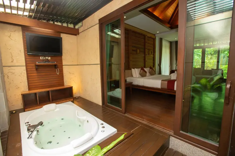 Une chambre lumineuse s'ouvre sur une terrasse avec un jacuzzi.