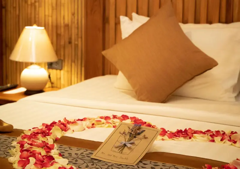 Un lit recouvert de pétales de fleurs dans une chambre décorée.