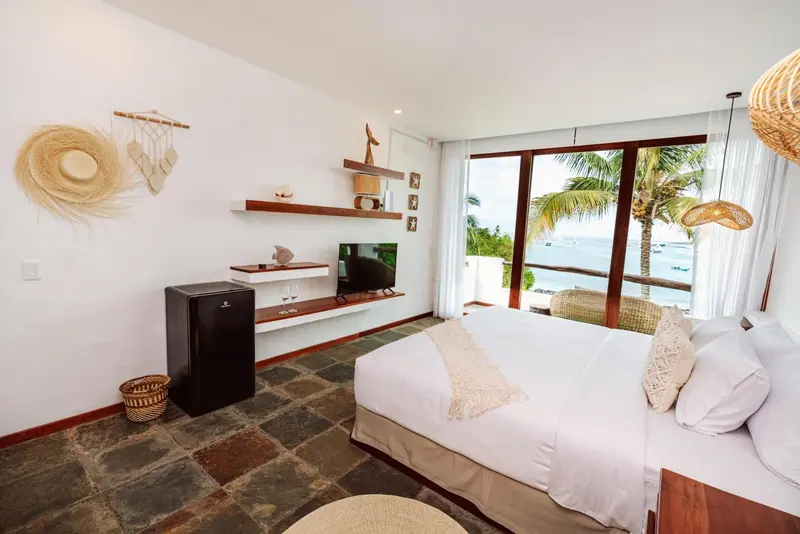 Une chambre lumineuse avec un grand lit et une vue sur la mer.