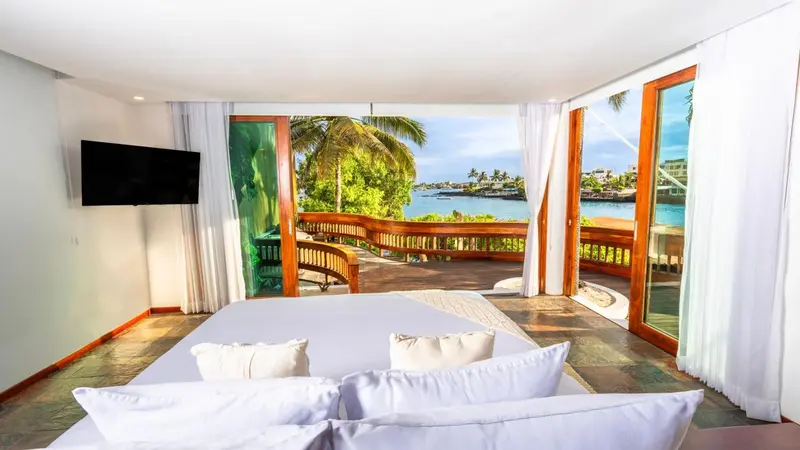 Une chambre lumineuse s'ouvre sur une terrasse avec vue sur la mer.