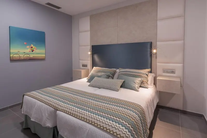 Une chambre moderne avec un grand lit et une décoration murale.