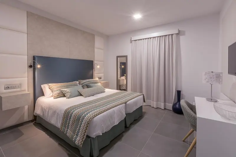 Une chambre moderne avec un grand lit et une décoration sobre.