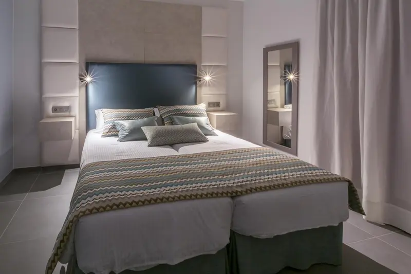 Une chambre moderne avec un grand lit recouvert d'une courtepointe décorative.
