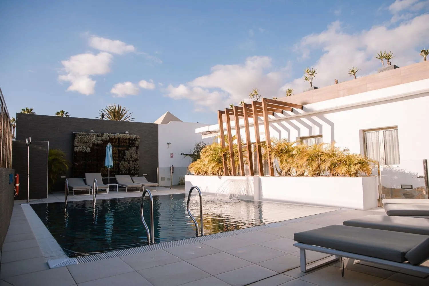 Terrasse avec piscine et mobilier de détente.