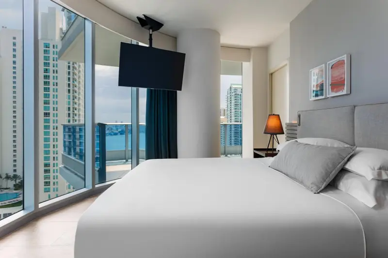 Une chambre lumineuse avec un grand lit et une vue sur la mer.