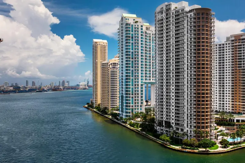 Vue d'ensemble de bâtiments modernes le long d'un canal urbain sous un ciel nuageux.