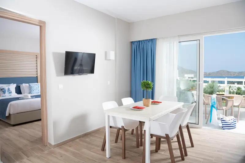 Une salle à manger lumineuse s'ouvre sur une chambre et une terrasse.