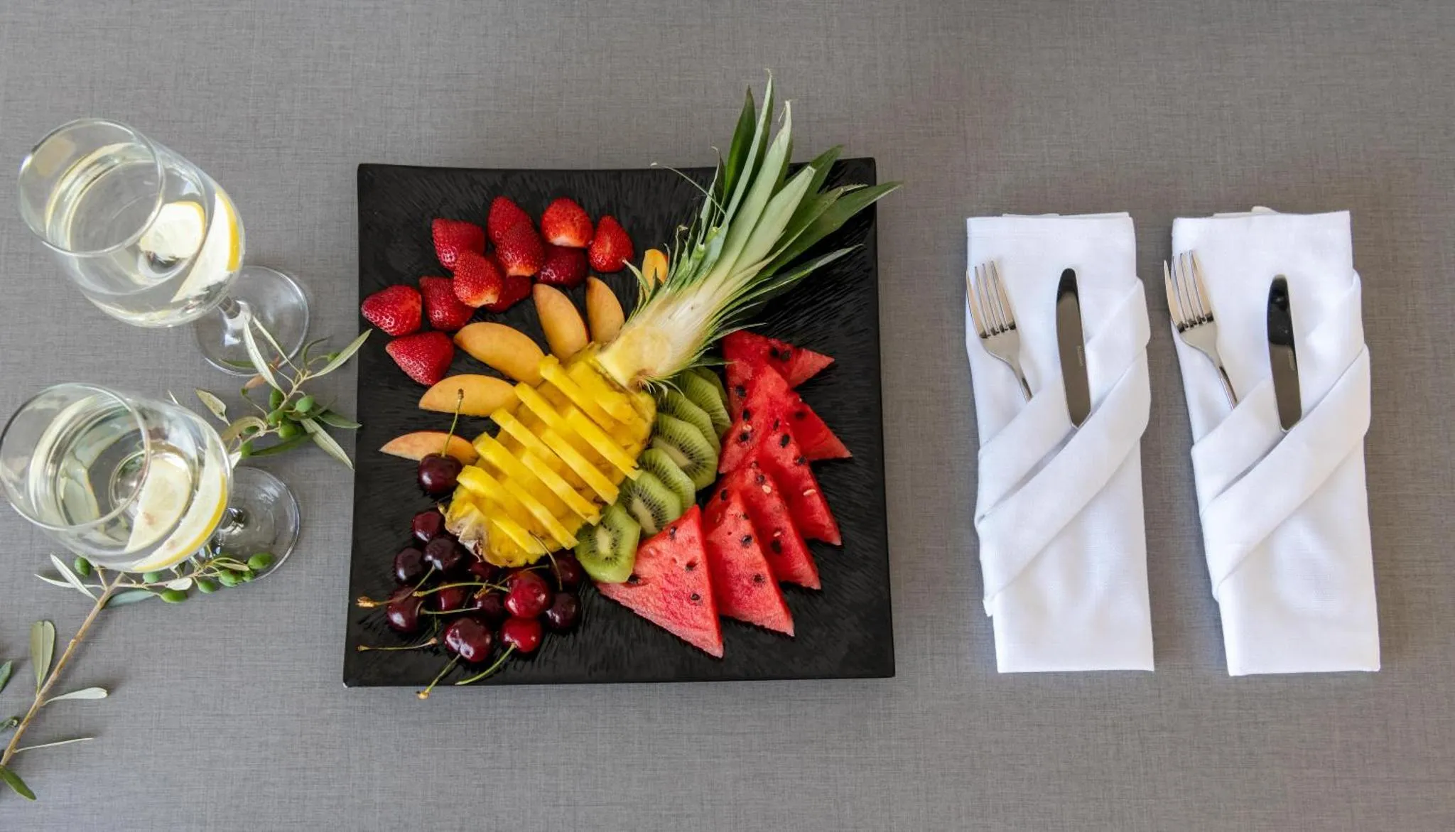 Assiette de fruits frais et boissons sur une table.