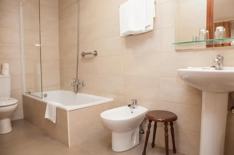 Une salle de bain claire avec baignoire et lavabo.