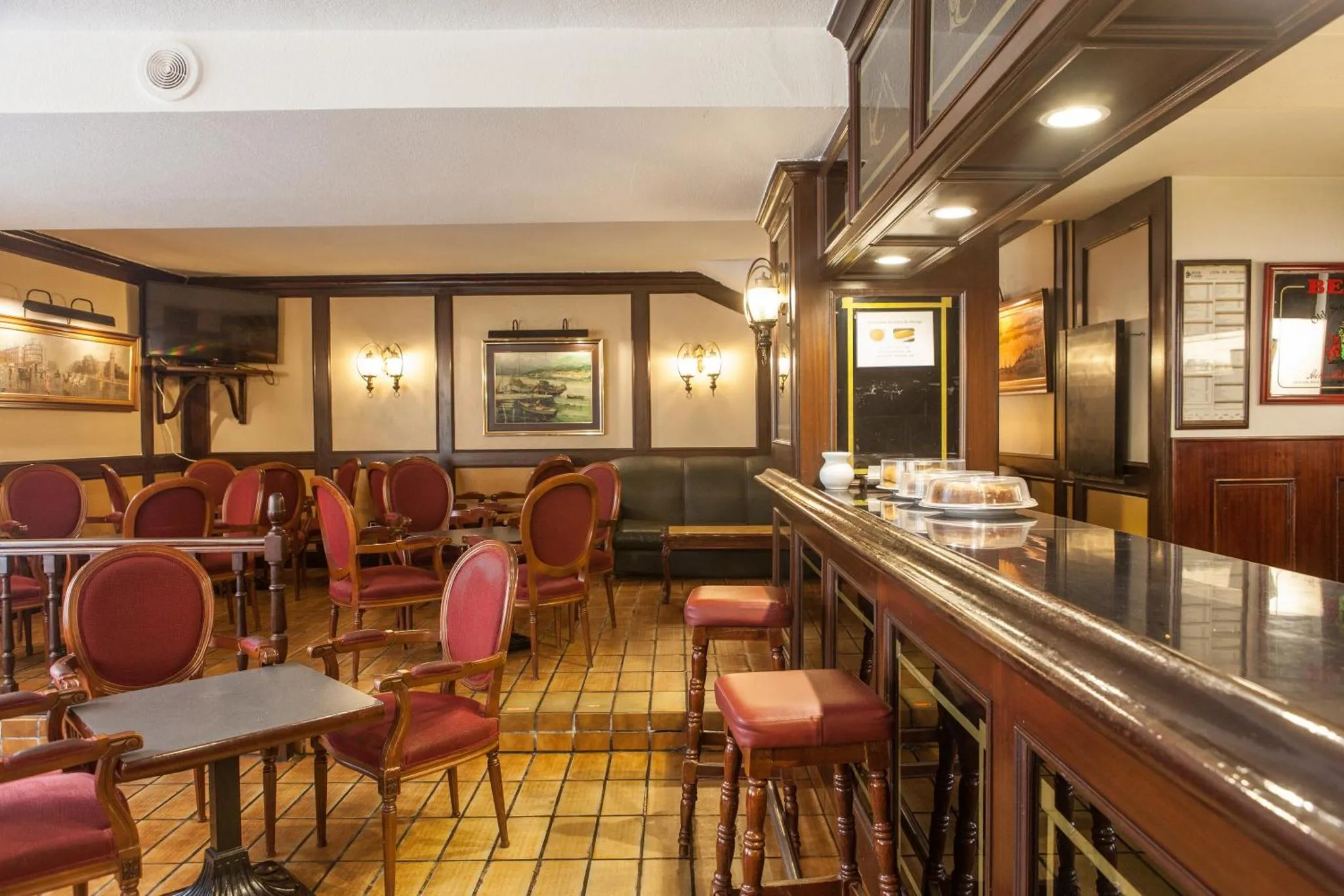 Une salle de restaurant avec des tables et un comptoir de bar en bois.