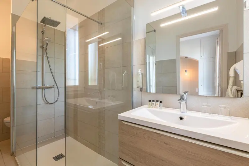 Une salle de bain moderne avec douche à l'italienne et vasque.
