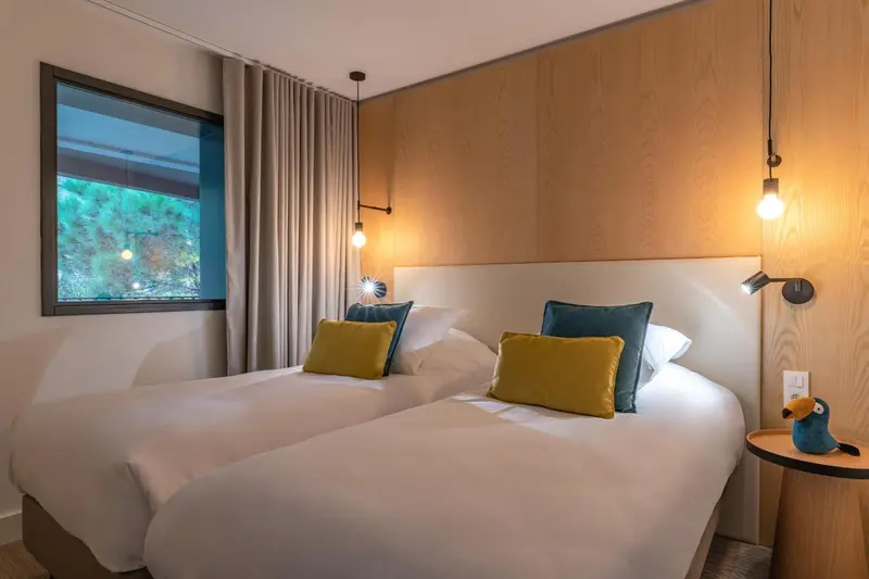 Une chambre lumineuse avec un grand lit et des oreillers colorés.