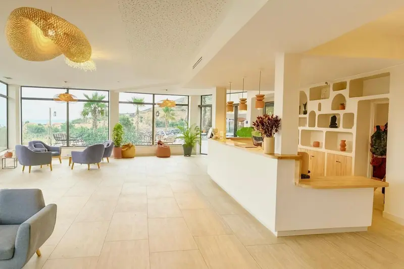 Espace de réception lumineux avec comptoir et mobilier contemporain.