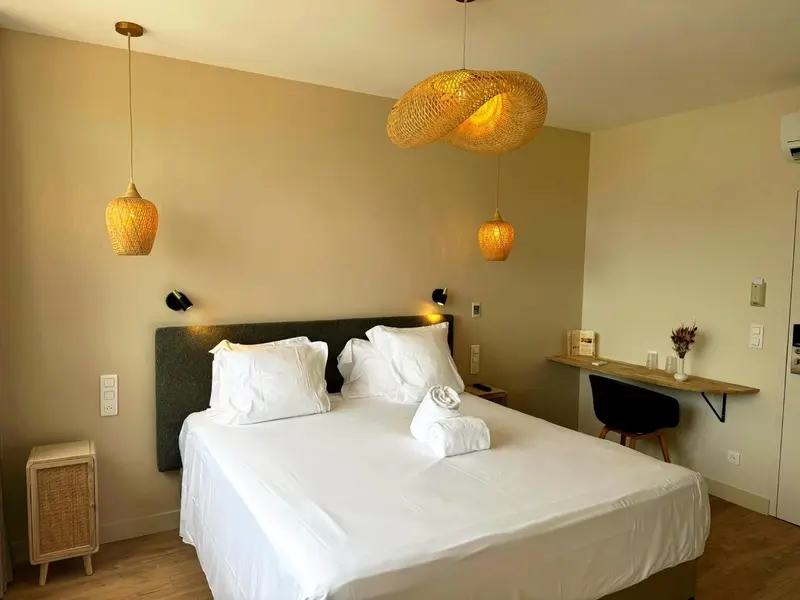 Une chambre lumineuse avec un grand lit et un bureau.