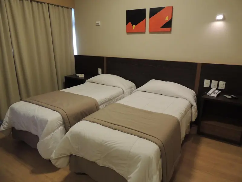 Une chambre avec deux lits simples et une décoration murale.