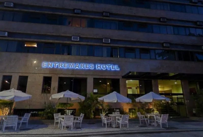 Façade d'un bâtiment avec des parasols et des tables en extérieur.