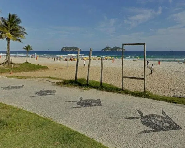 Une plage de sable avec des palmiers et des silhouettes de tortues dessinées sur le sol.