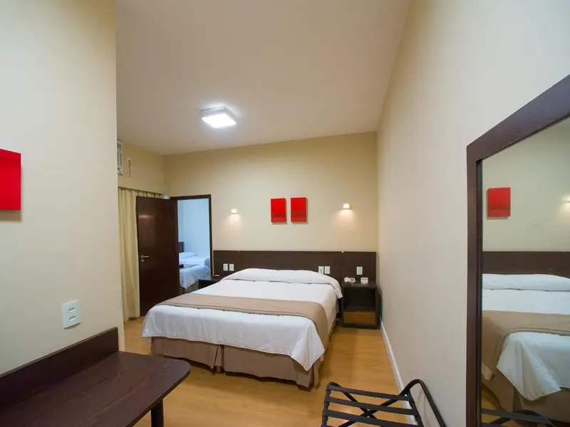 Chambre lumineuse avec un lit double et un miroir.