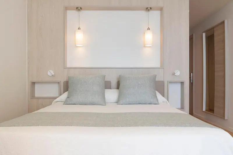 Une chambre avec un grand lit et des luminaires suspendus.