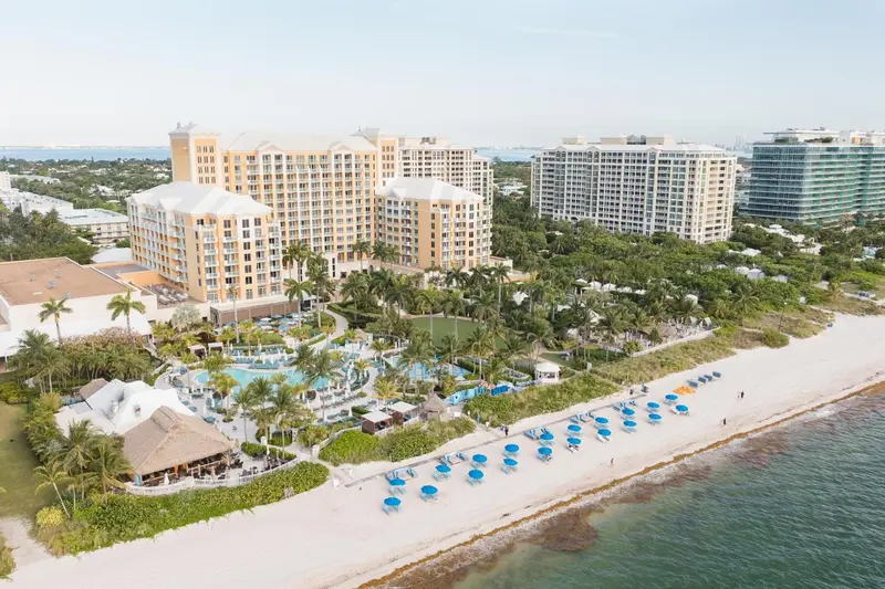 Vue aérienne d'un complexe hôtelier bordant une plage de sable fin.