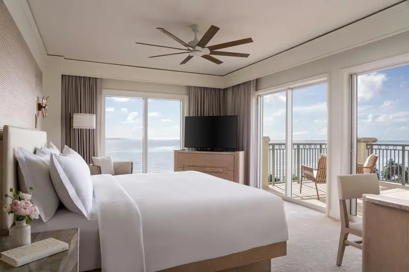 Une chambre lumineuse avec un grand lit et une vue sur la mer.