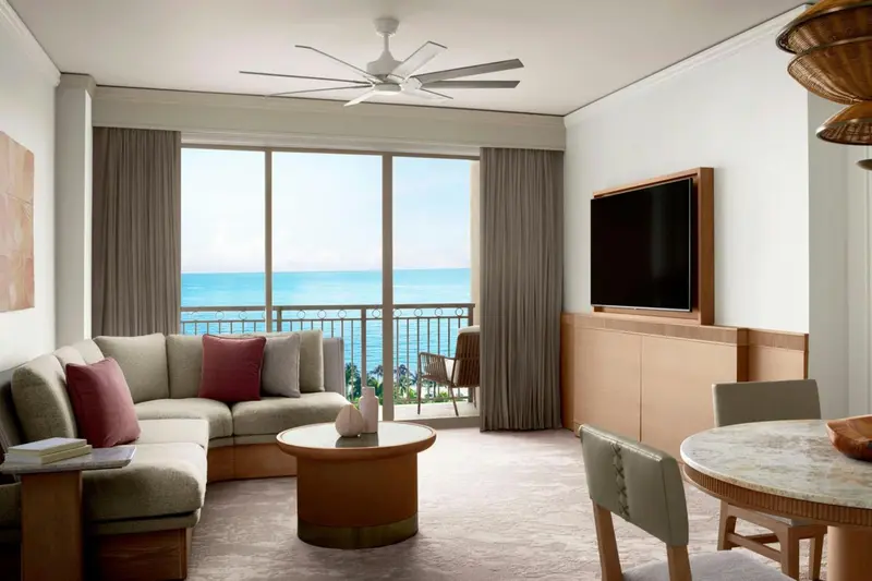 Un salon lumineux s'ouvre sur une vue mer par de grandes baies vitrées.
