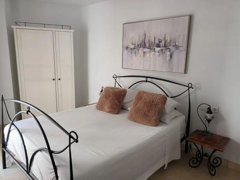 Une chambre avec un lit double et une armoire.