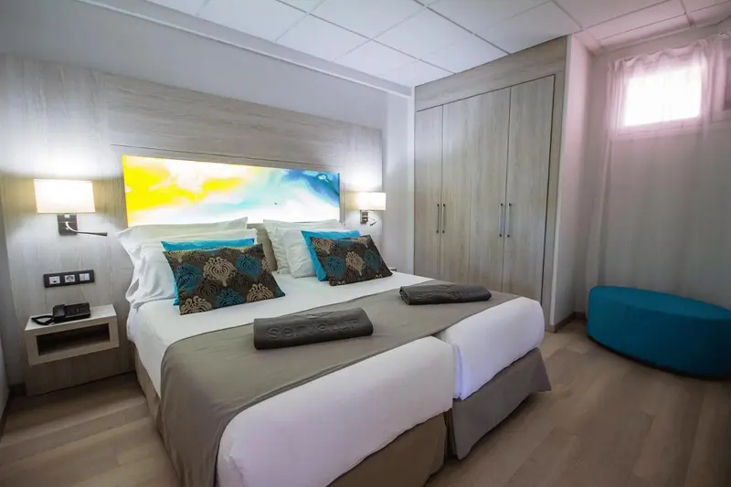 Une chambre lumineuse avec un grand lit et une décoration colorée.