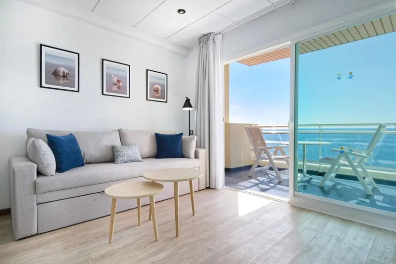 Un salon clair s'ouvre sur une terrasse avec vue sur la mer.