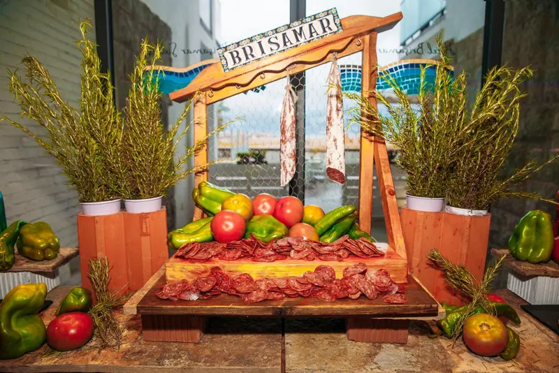 Présentation de charcuterie et de légumes frais sur un étal décoré.