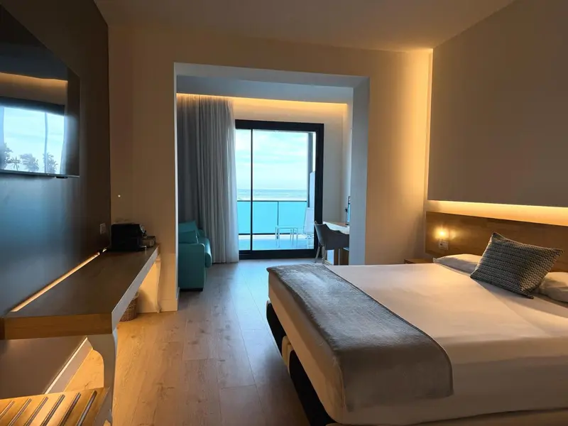 Une chambre lumineuse avec un lit et un canapé donnant sur la mer.