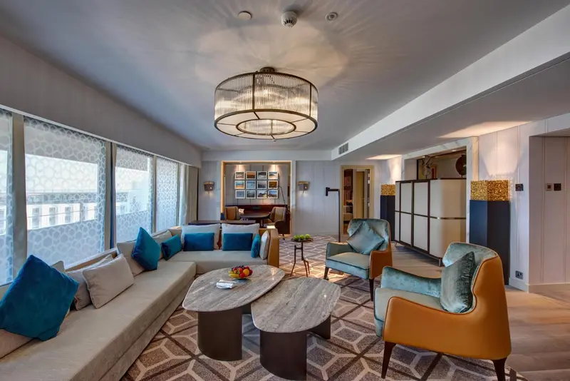 Un salon spacieux et lumineux avec canapés et fauteuils.