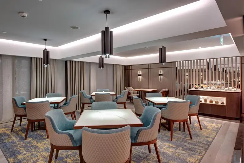 Une salle lumineuse avec des tables et des chaises confortables.