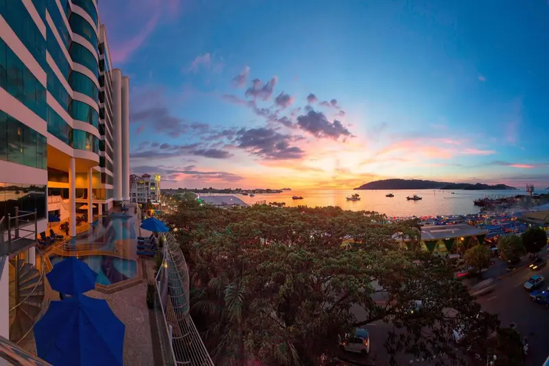 Vue panoramique sur la mer au coucher du soleil depuis une terrasse d'hôtel.