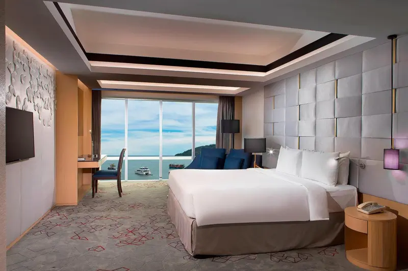 Chambre moderne avec un grand lit et une vue sur la mer.