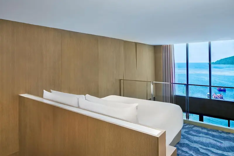Une chambre lumineuse avec un grand lit et une vue sur la mer.