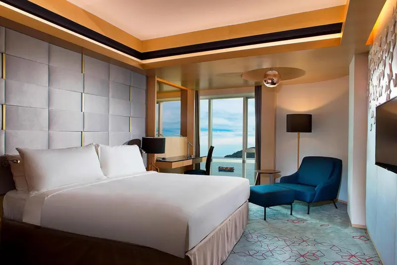 Une chambre lumineuse avec un grand lit et un coin salon.