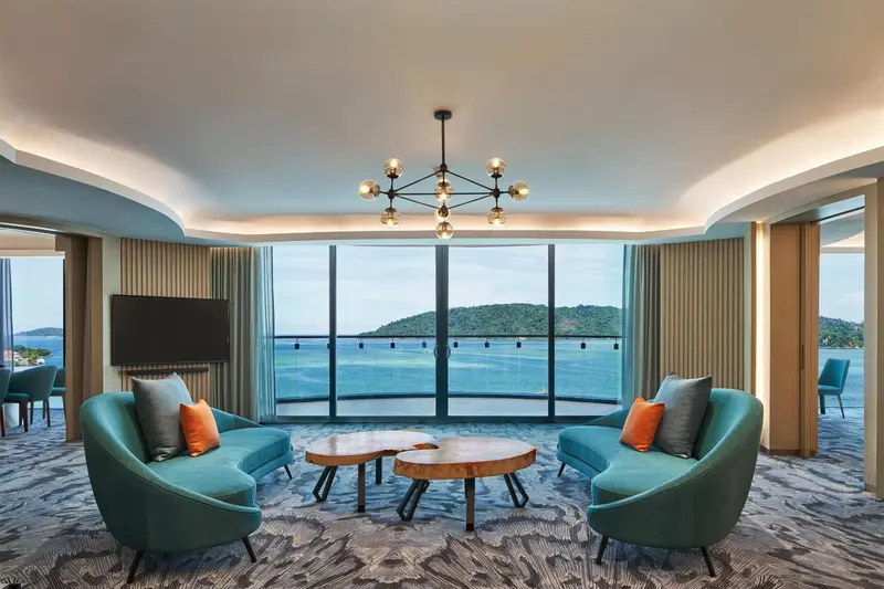 Espace de détente lumineux avec canapés et vue sur la mer.