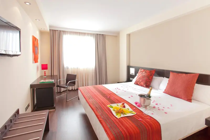 Une chambre d'hôtel avec un lit décoré et un bureau.
