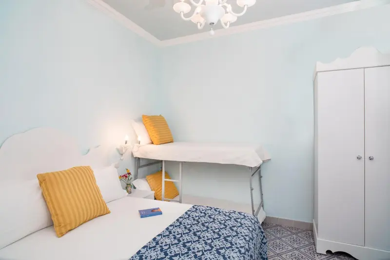 Une chambre lumineuse avec deux lits simples et une décoration claire.