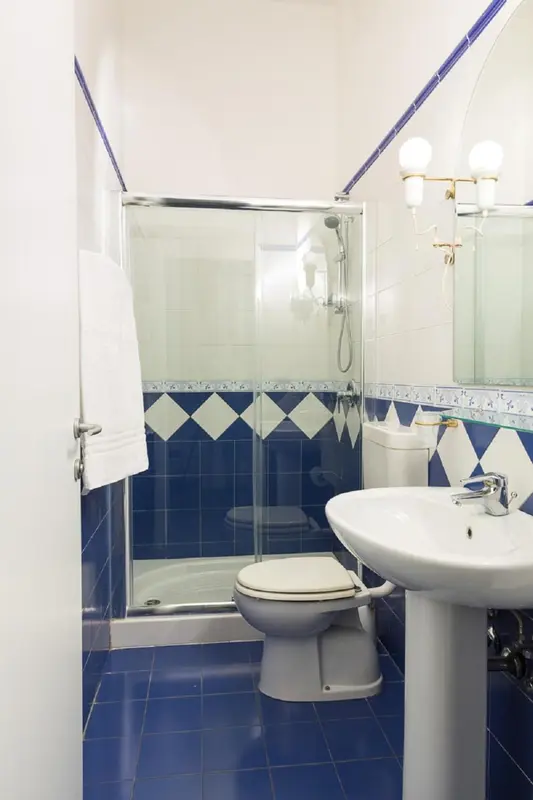 Une salle de bain claire avec douche et lavabo.