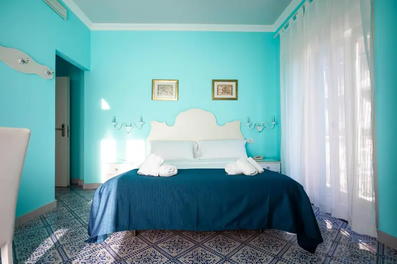 Une chambre lumineuse avec un grand lit recouvert de couvertures et d'oreillers.